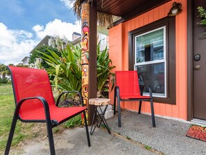 A building with two red chairs and a small round table outside.