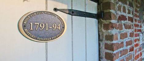 A plaque on a white wooden door with a metal bracket, indicating the building was built for Paul Hamilton Williams in 1791-94.
