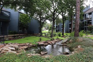 Escape to a serene courtyard surrounded by mature trees and a small water feature.