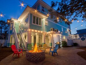 A two-story house with a covered patio area, outdoor seating, and a fire pit. - Harrisons Hideaway by Tybee Vacation Rentals (Tybee Island)