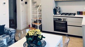 A modern apartment with a kitchen, dining area, and a staircase leading to an upper level. - Finely renovated house, a few steps from the sea (Isola delle Femmine)