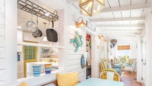 A bright, open-plan living area with a kitchen, dining table, and seating area. - Island Bliss Tybee Vacation Rentals (Tybee Island)