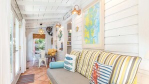 A cozy interior with a sofa, cushions, and a map on the wall. - Island Bliss Tybee Vacation Rentals (Tybee Island)