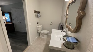 A bathroom with a toilet, sink, and mirror. - The Inn at Dirickson Creek - Room Three (Frankford)