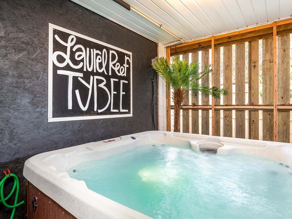 Een bubbelbad met een bord waarop 'Laurel Reef TVBEE' staat, tegen een donkere muur.