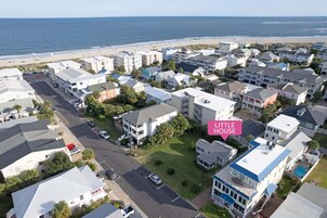 An aerial view of a residential area with houses, a beach, and a road.