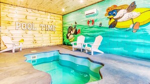 Uima-allasalue, jossa on puinen seinä ja seinämaalaus, johon kuuluu teksti ”POOL TIME” ja ankankuva.