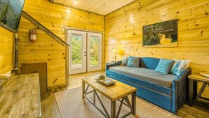 Un intérieur en bois avec un canapé, une table et un ventilateur de plafond.