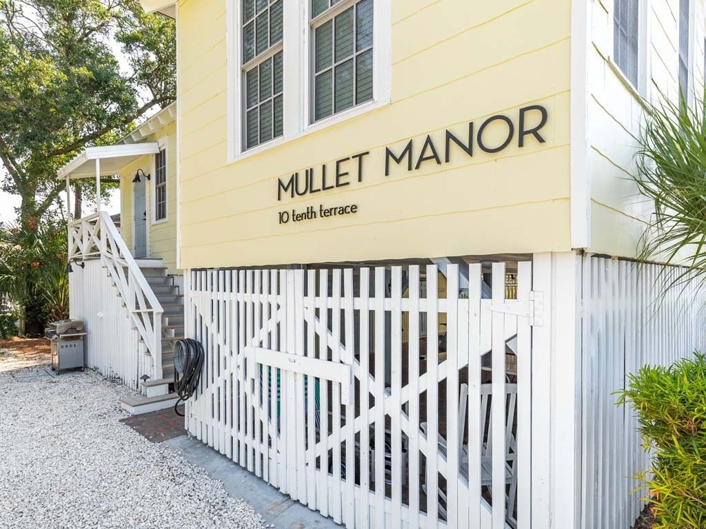 A yellow building with a sign reading "MULLET MANOR 10th terrace".