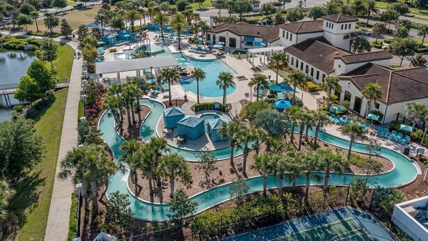 Un complexe hôtelier doté de plusieurs piscines, de palmiers et d’un grand bâtiment surmonté d’un toit en tuiles.