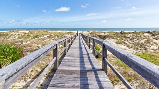 Une promenade en bois qui mène à la plage.