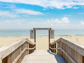 A wooden boardwalk leading to a beach with a sign reading "Center Street" and another sign with beach rules. - Once Upon A Tide by Tybee Vacation Rentals (Tybee Island)