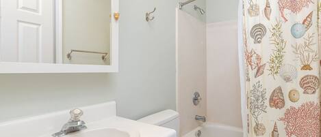 A bathroom with a sink, toilet, and bathtub.