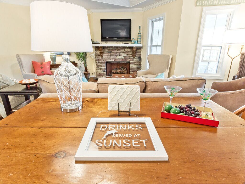 A cozy living room with a fireplace, a television, and a table set for drinks.