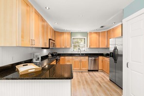 Enjoy cooking in this well-equipped kitchen with a refrigerator, dishwasher, and microwave.