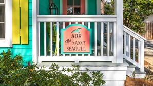 A house with a porch, a sign reading "809 The Sassy Seagull," and a mailbox. - Sassy Seagull by Tybee Vacation Rentals (Tybee Island)