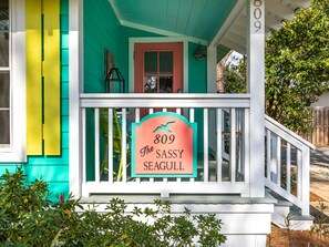 Welcome to The Sassy Seagull, a charming house with a distinctive porch and a warm red door.
