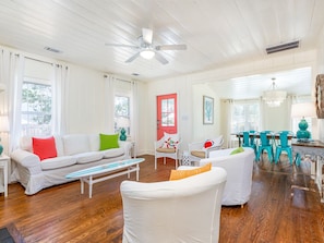 Relax in this stylish living room with a sofa, armchair, and dining area.