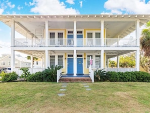 Traditional two-story residence with a central entrance and well-manicured lawn.