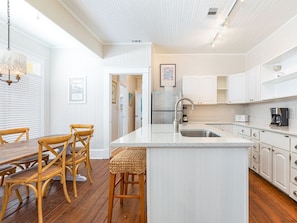 Enjoy cooking in this well-equipped kitchen with a central island, stainless steel appliances, and a dining area.