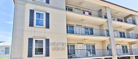 A multi-story hotel with balconies, a parking garage, and a sign reading "Silver Seas".