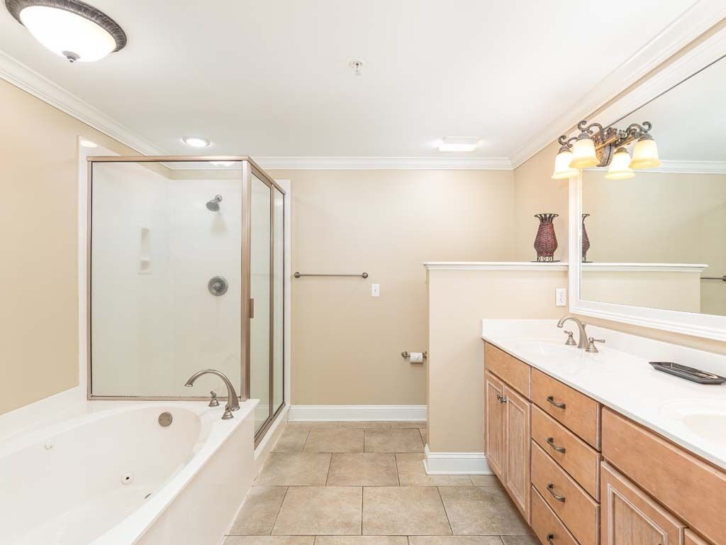 Une salle de bain avec une baignoire, une douche, un meuble-lavabo et un grand miroir.