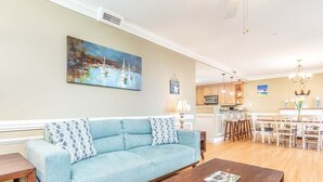 Ein Wohnzimmer mit einem hellblauen Sofa, einem Holztisch und einem Bild an der Wand.