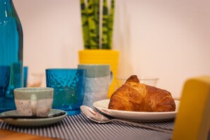 Un tavolo con un croissant, una tazza e un cucchiaio.