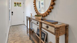 A hallway with a wooden console table, a mirror with a wooden frame, and a door with a window. - On Austin Ave!!! Completely remodeled and close to Magnolia, Downtown & Baylor.  (Waco)