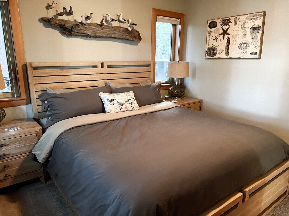 Ein Schlafzimmer mit einem großen Bett, einem Holzkopfstück und einem Nachttisch mit einer Lampe.