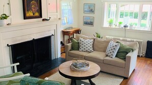 A living room with a fireplace, a sofa, a coffee table, and a chair.