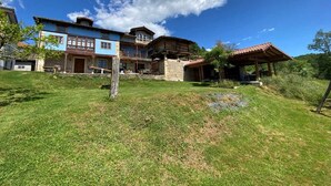 A large, multi-story building with a stone facade and a blue upper level. - RURAL TYPICAL ASTURIAS'S HOME (Prunales)