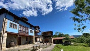 A traditional building with a stone facade, a wooden balcony, and a red-tiled roof. - RURAL TYPICAL ASTURIAS'S HOME (Prunales)