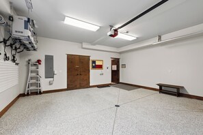 Una habitación amplia con techo alto, puerta de madera, una bandera y un banco.