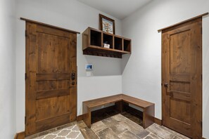 A hallway with wooden doors, a bench, and a wall-mounted shelf with a framed picture. - 1.5 mi to Gondola/Town, 5-Star Perfection, Views (Breckenridge)