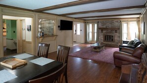 A spacious living room with a fireplace, a dining area with a wooden table and chairs, and a leather sofa. - Spacious & Quiet 5 beds, 3.5 bathroom home away from home in Katy, Texas (Katy)