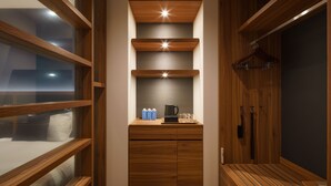A narrow hallway with wooden flooring and built-in shelving units on both sides.