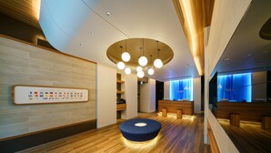 A modern reception area with a wooden floor, a blue seating area, and a wall-mounted flag display.