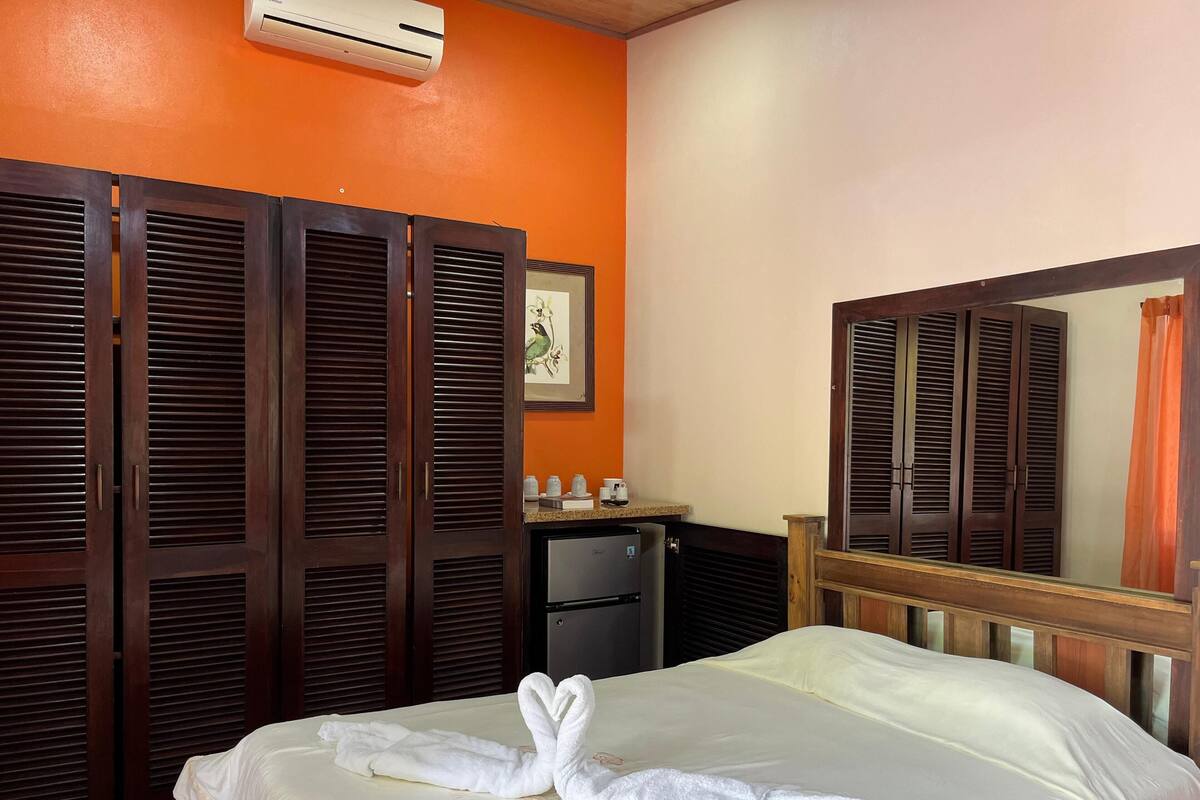 Una camera d'albergo con un letto, una scrivania e un armadio.