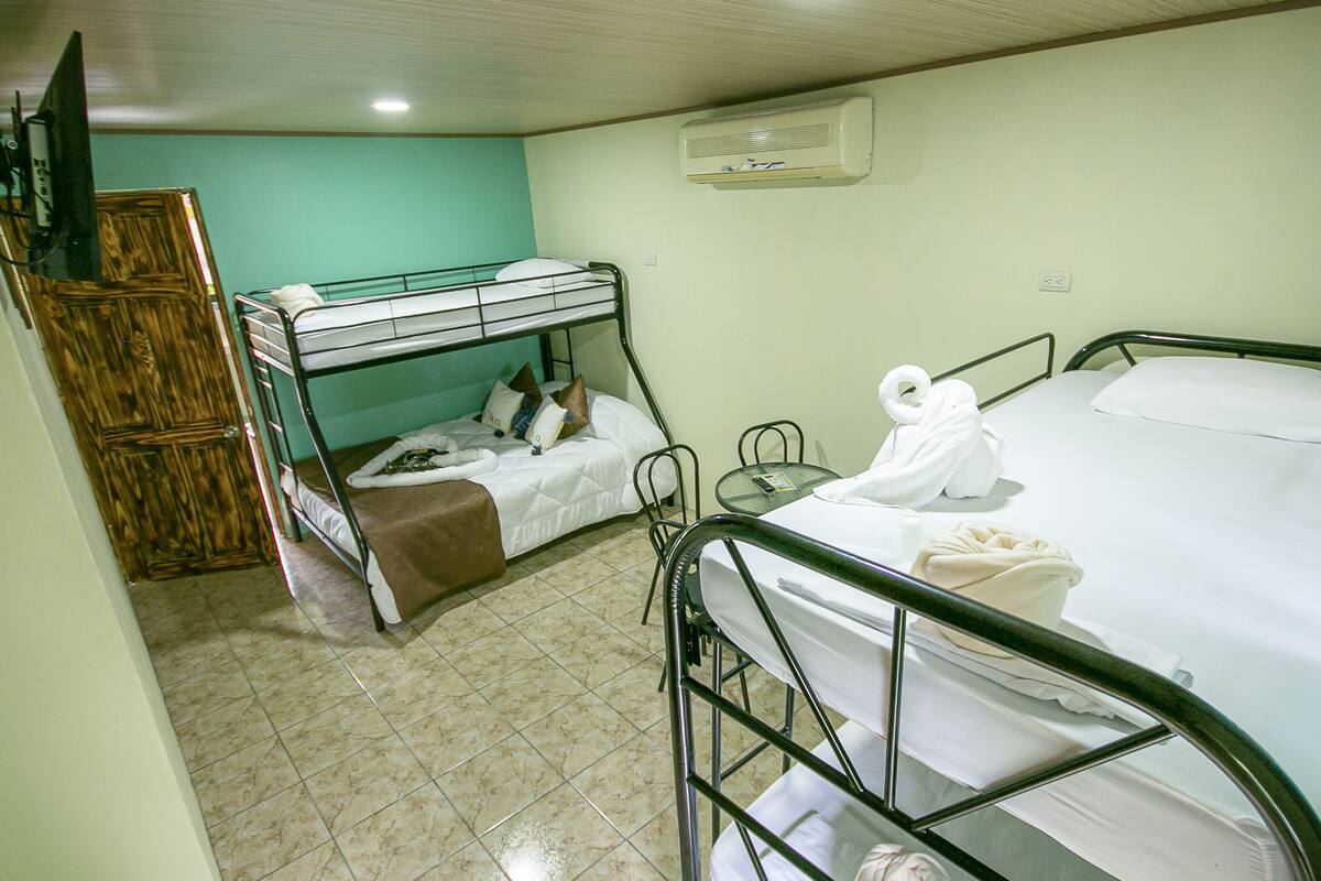 Una camera del dormitorio con letti a castello, un tavolino e una sedia.