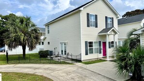 A two-story residential building with a white exterior, black shutters, and a pink door. - Lovely Home Near Myrtle Beach (Myrtle Beach)