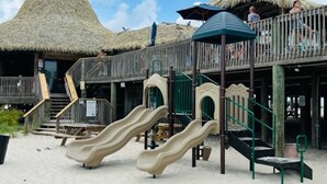 A beachside playground with slides and a thatched-roof structure. -  Beach. Walk everywhere. Peaceful. Location. (Navarre)