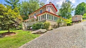 A two-story house with a porch, a flag, and a small shed. - Fish, Float & Relax Fireside: Home Near New River! (Crumpler)