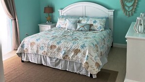 Un dormitorio con cama, mesita de noche y decoración en la pared.