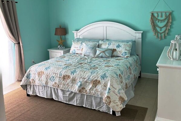A bedroom with a bed, nightstand, and wall decor.