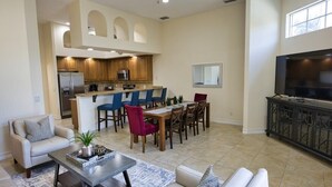 Amplia sala de estar con cocina, mesa de comedor y asientos.