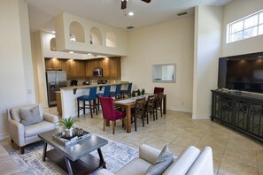 A spacious living area with a kitchen, dining table, and seating.