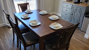 Une table à manger dressée avec des assiettes, des bols et des couverts.
