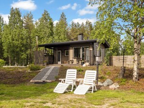 A modern house with a patio, outdoor seating, and a chimney.