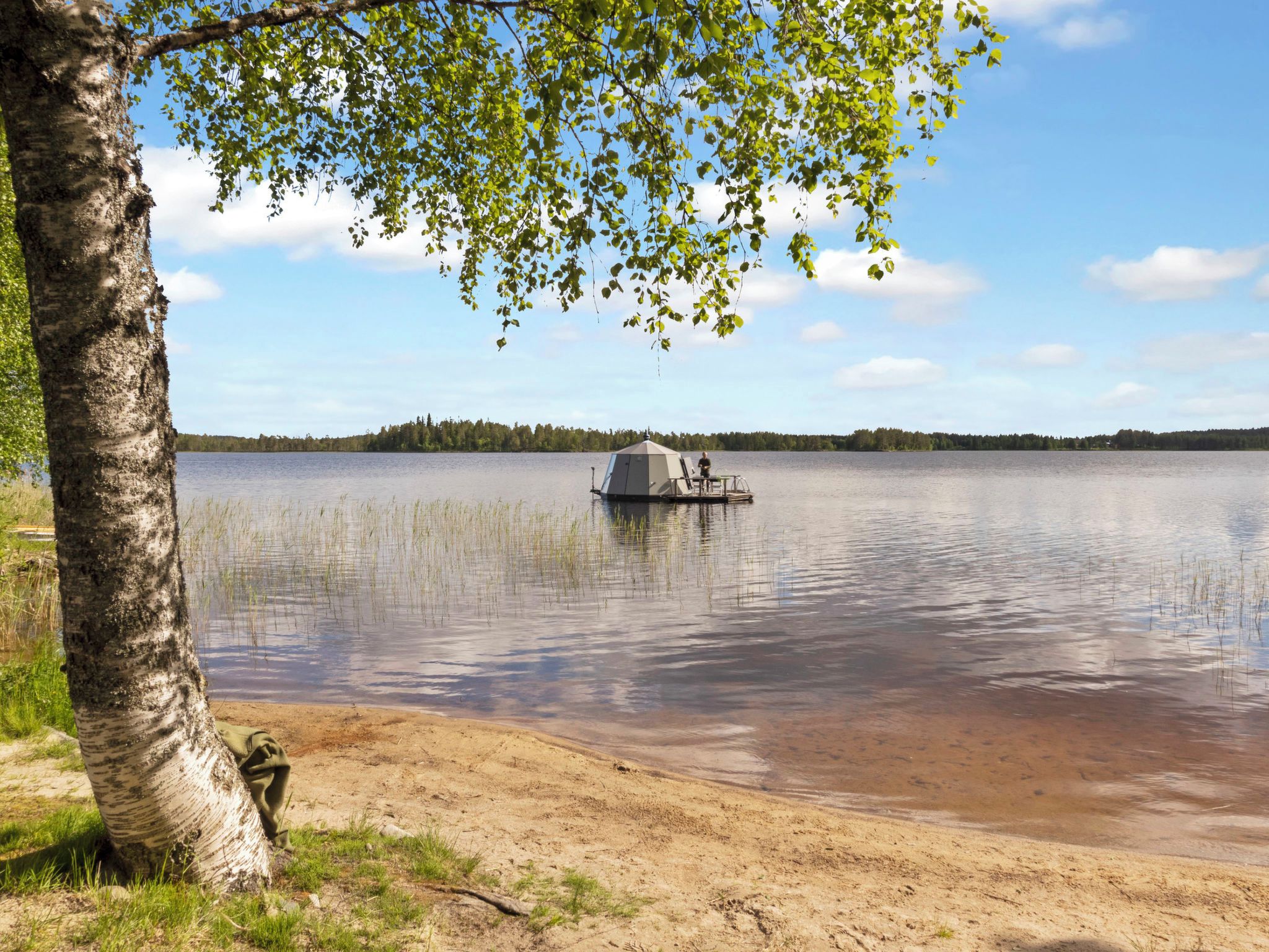 A lake with a dock and a tent.